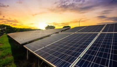 Painéis solares captando luz do sol ao entardecer, representando o uso de energia híbrida e sustentável.